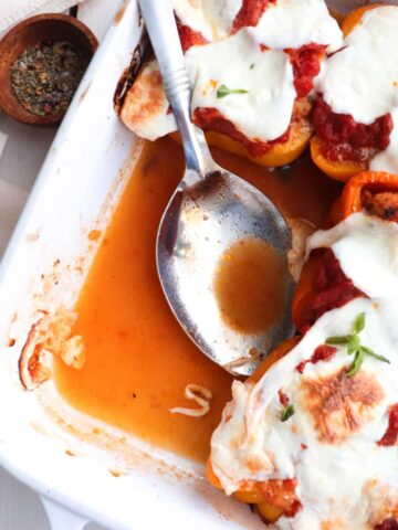 chicken parm stuffed peppers in a white dish with two removed