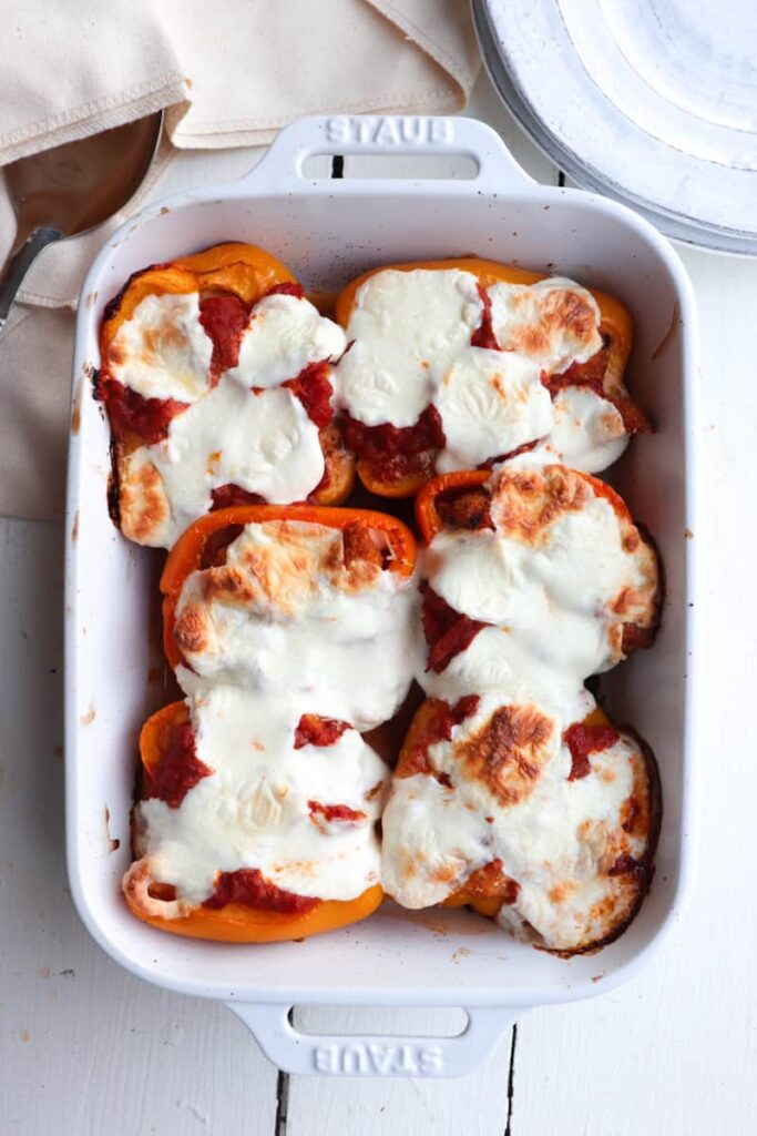 chicken parm stuffed peppers in a white dish