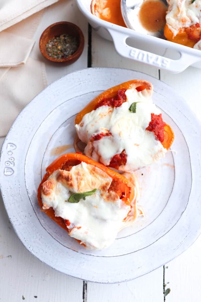 two chicken parmesan stuffed peppers on a white plate