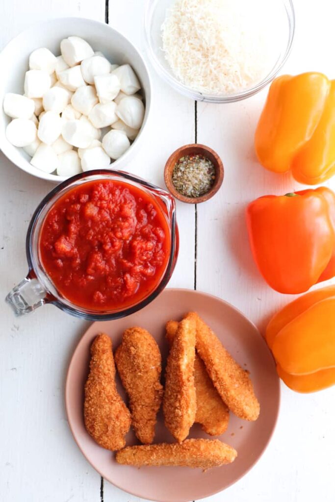 ingredients for chicken parmesan stuffed peppers on a white background