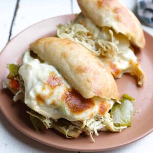 two sandwiches with melted cheese on a plate