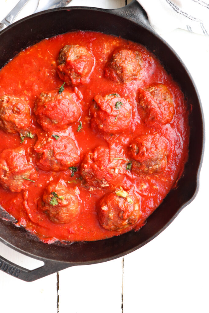finished stuffed meatballs and sauce in is cast iron skillet