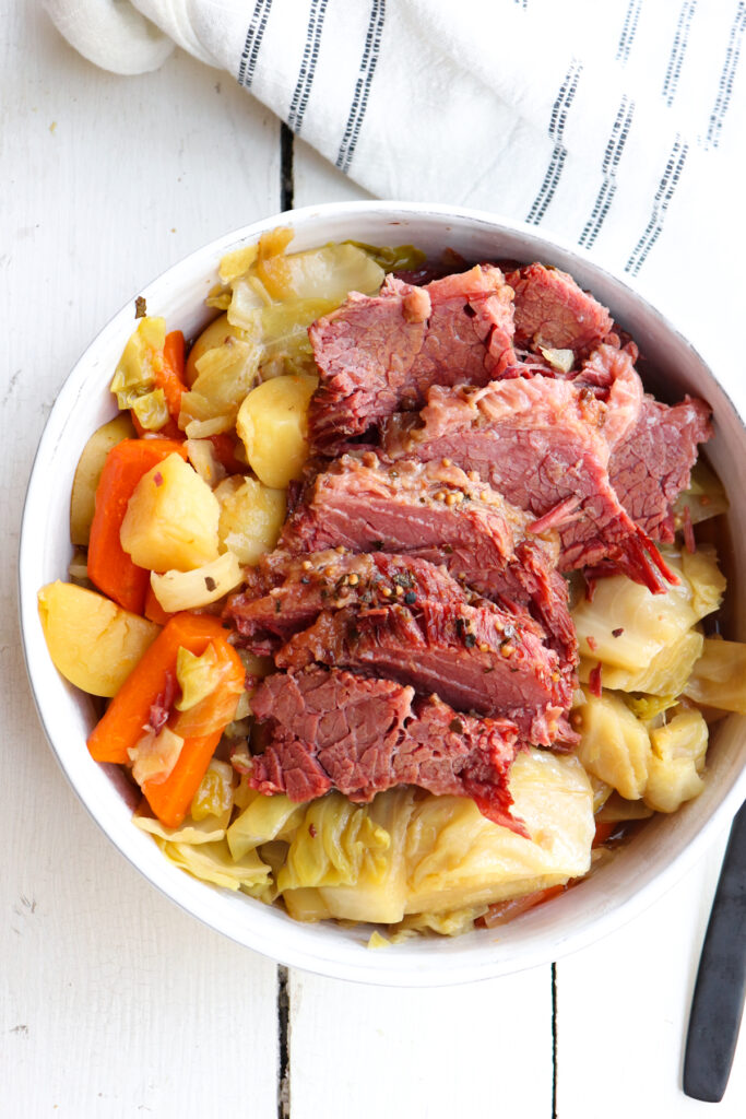 sliced corned beef on a bed of cooked cabbage.