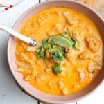 spicy cauliflower soup in a bowl and garnish with lime and cilantro