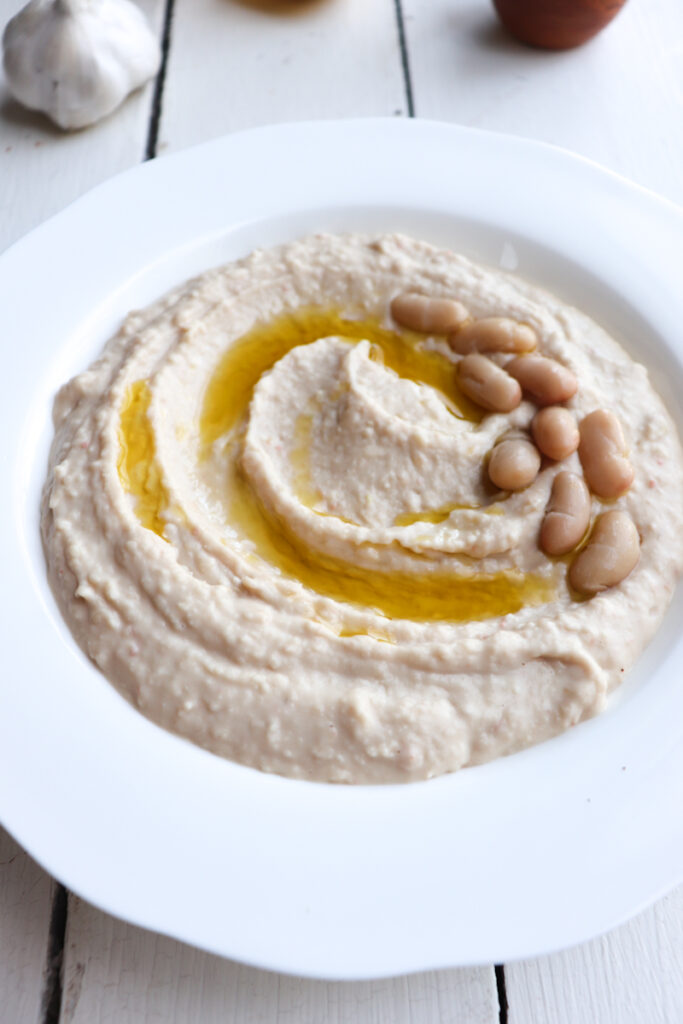 bowl filled with white bean hummus and drizzled with oil