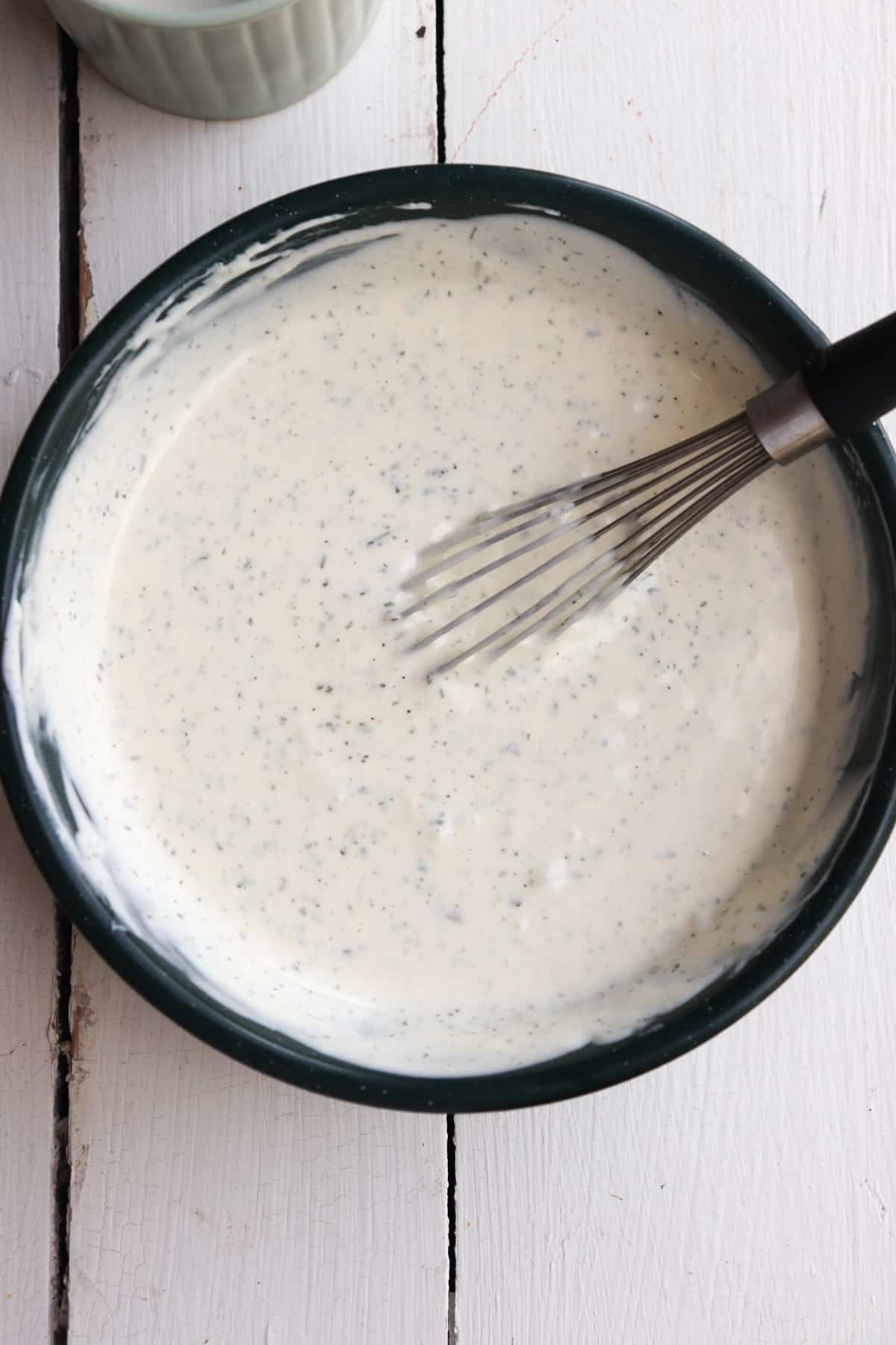 ranch shown in a bowl with a whisk.