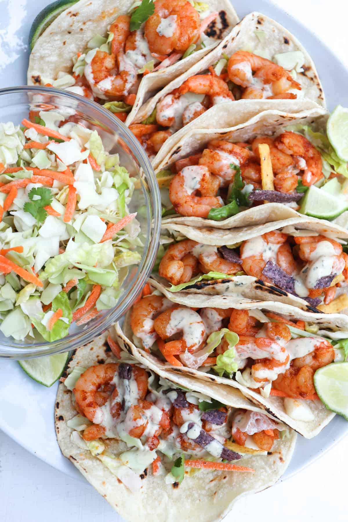 plate of shrimp tacos with cabbage to the side.