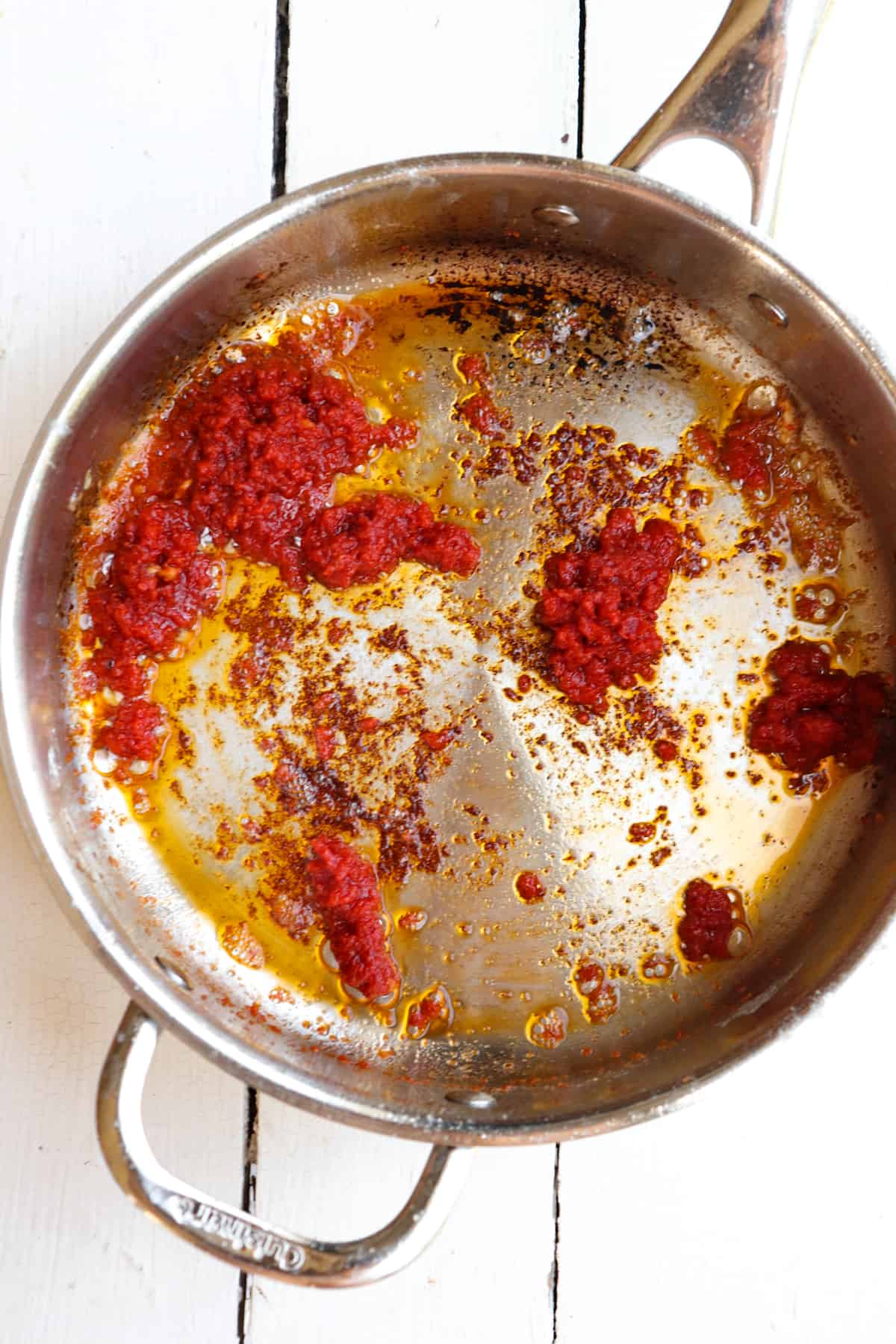 caramelized tomato paste in a stainless steel pan.