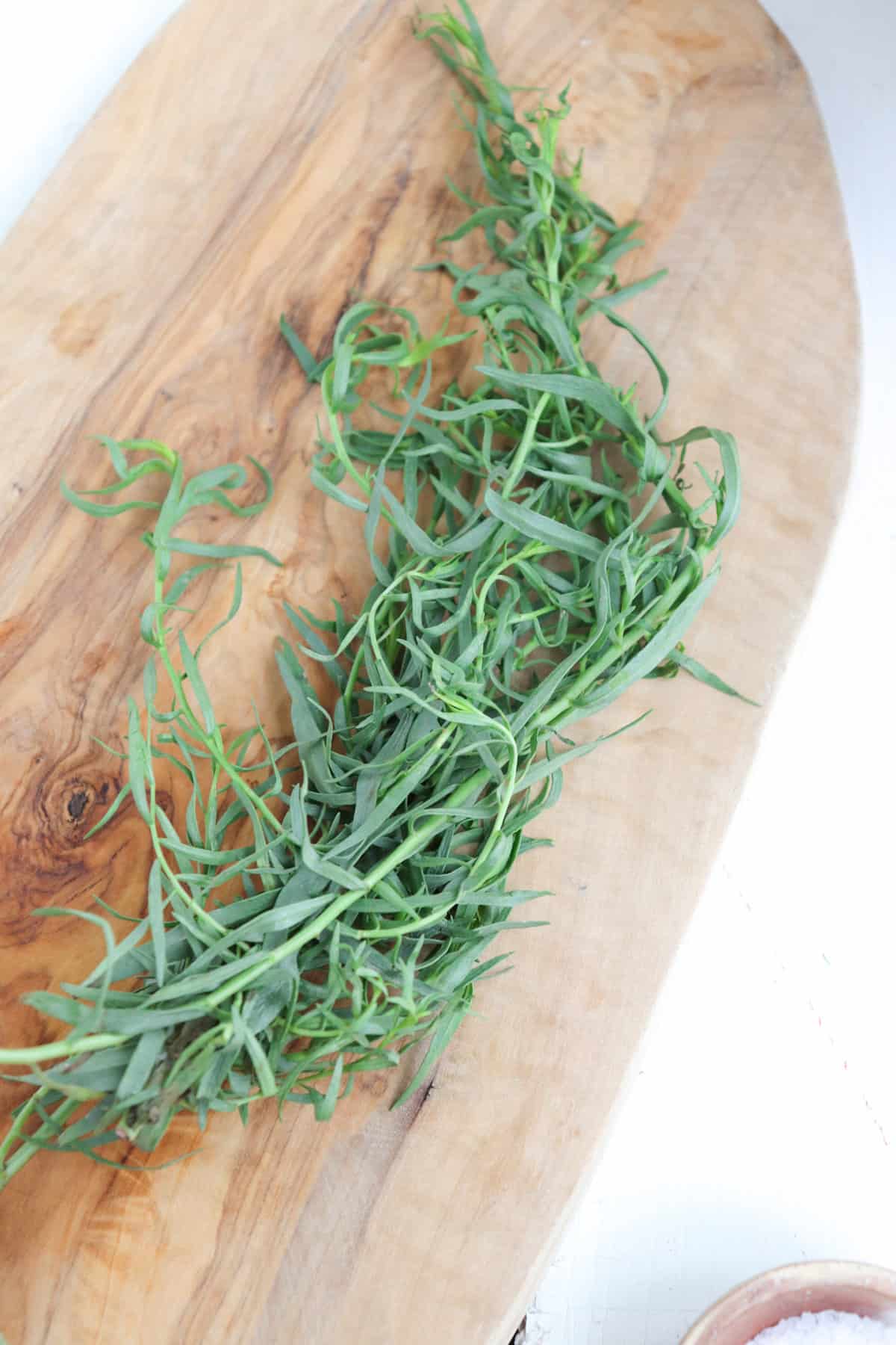 tarragon on a wooden cutting board.