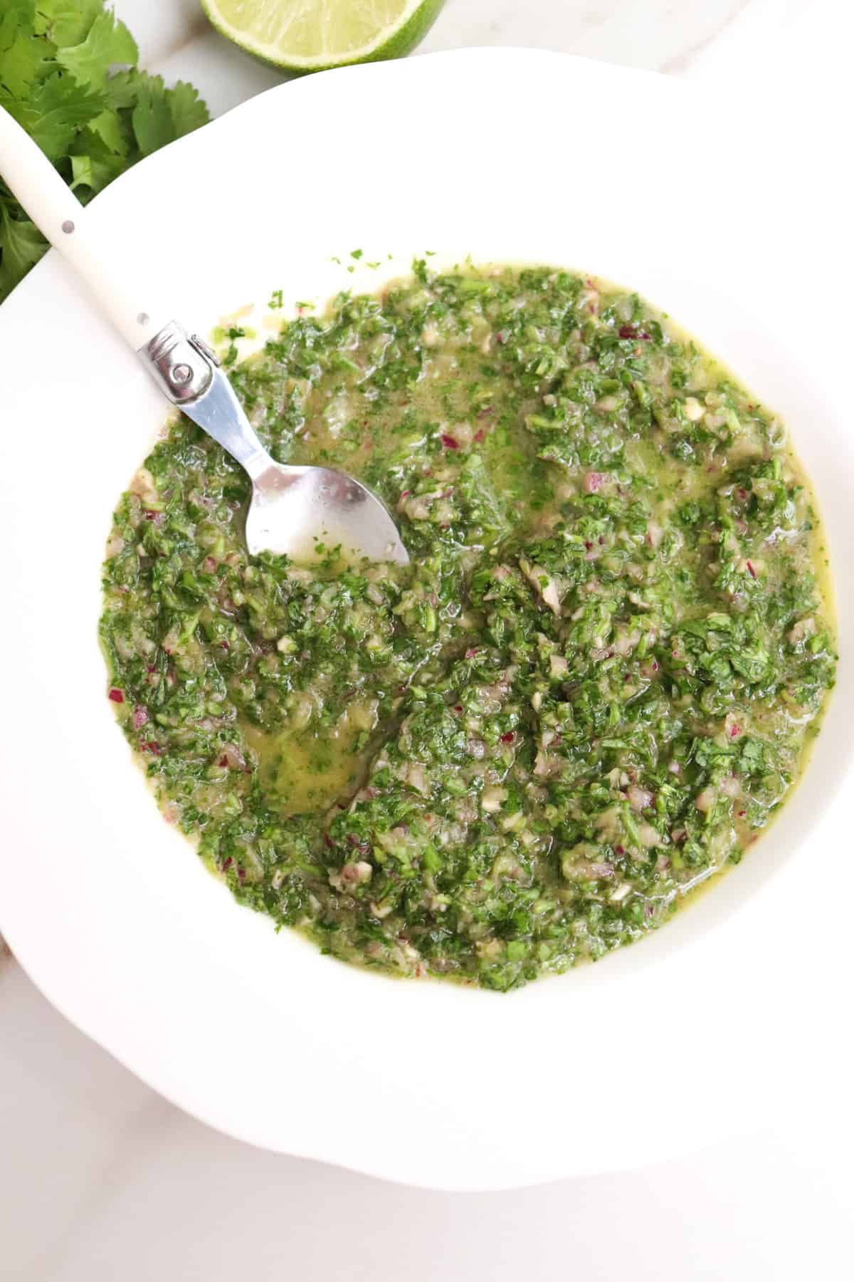 bowl full of chimichurri with a spoon.