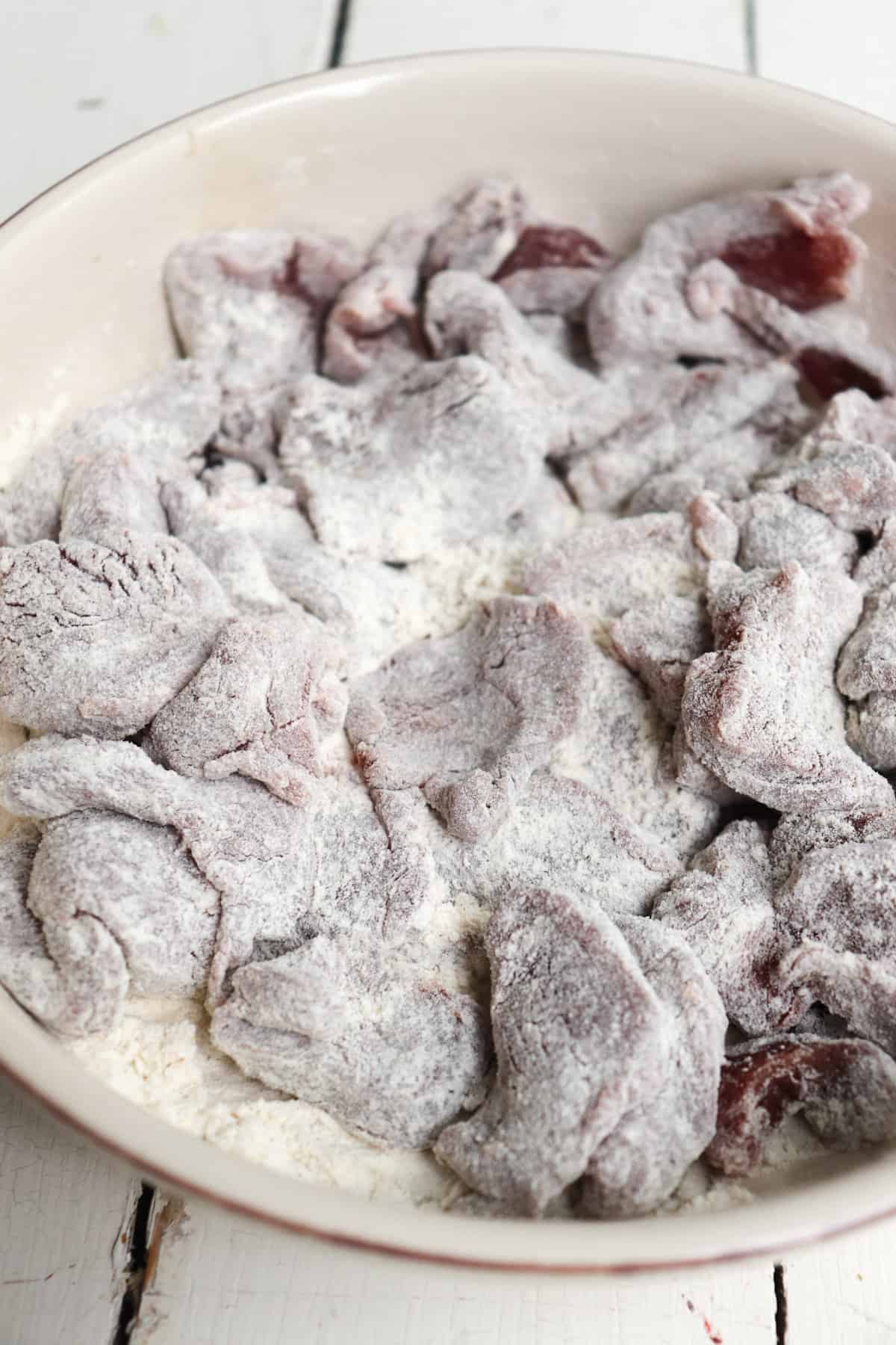 venison slices coated in flour.