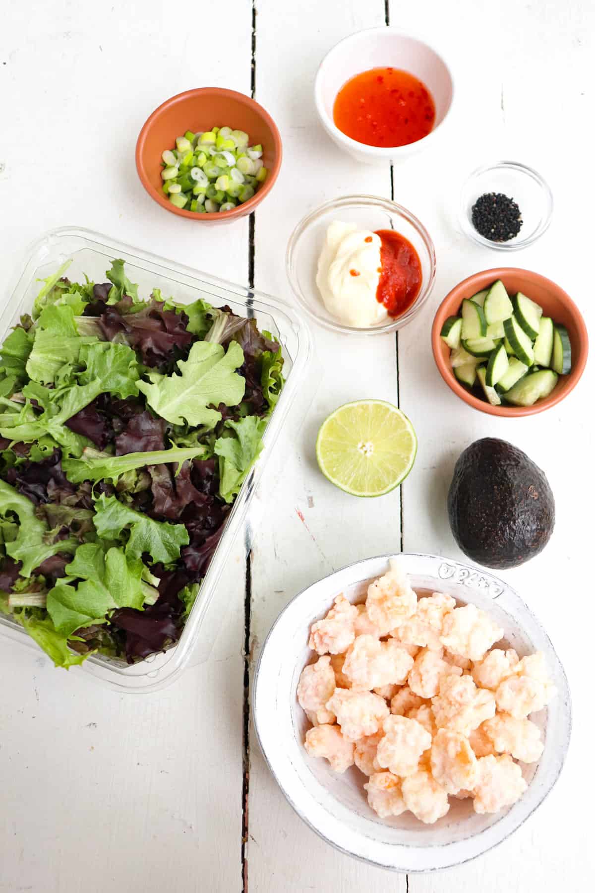 ingredients for bang bang shrimp salad with sriracha mayo on a white table.