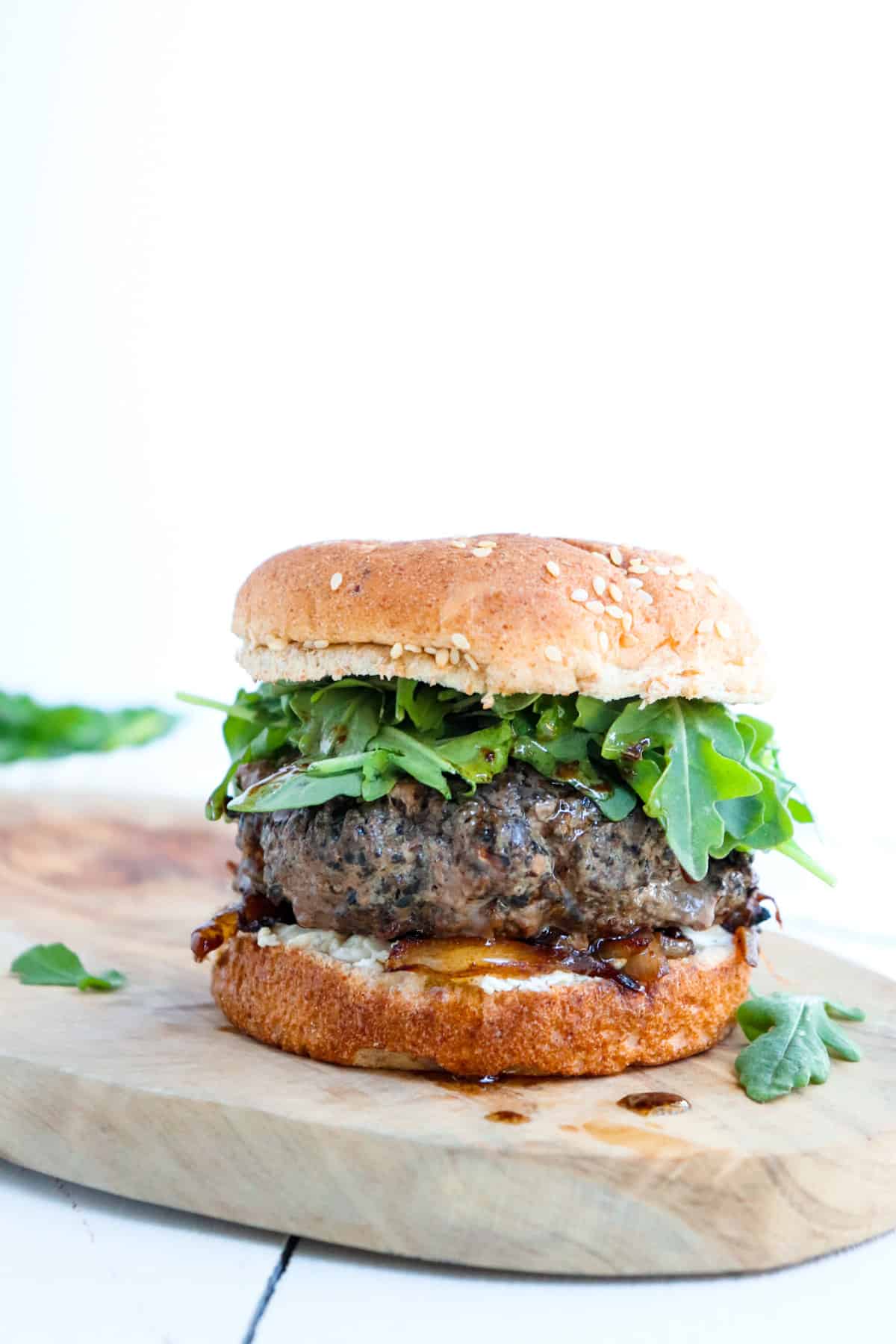 plated burger with arugula scattered around.
