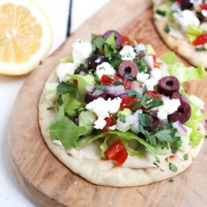 greek flatbread with olives on top.