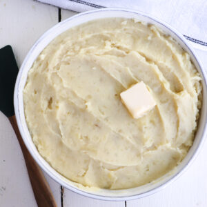 mashed potatoes in a serving dish with a black spoon.