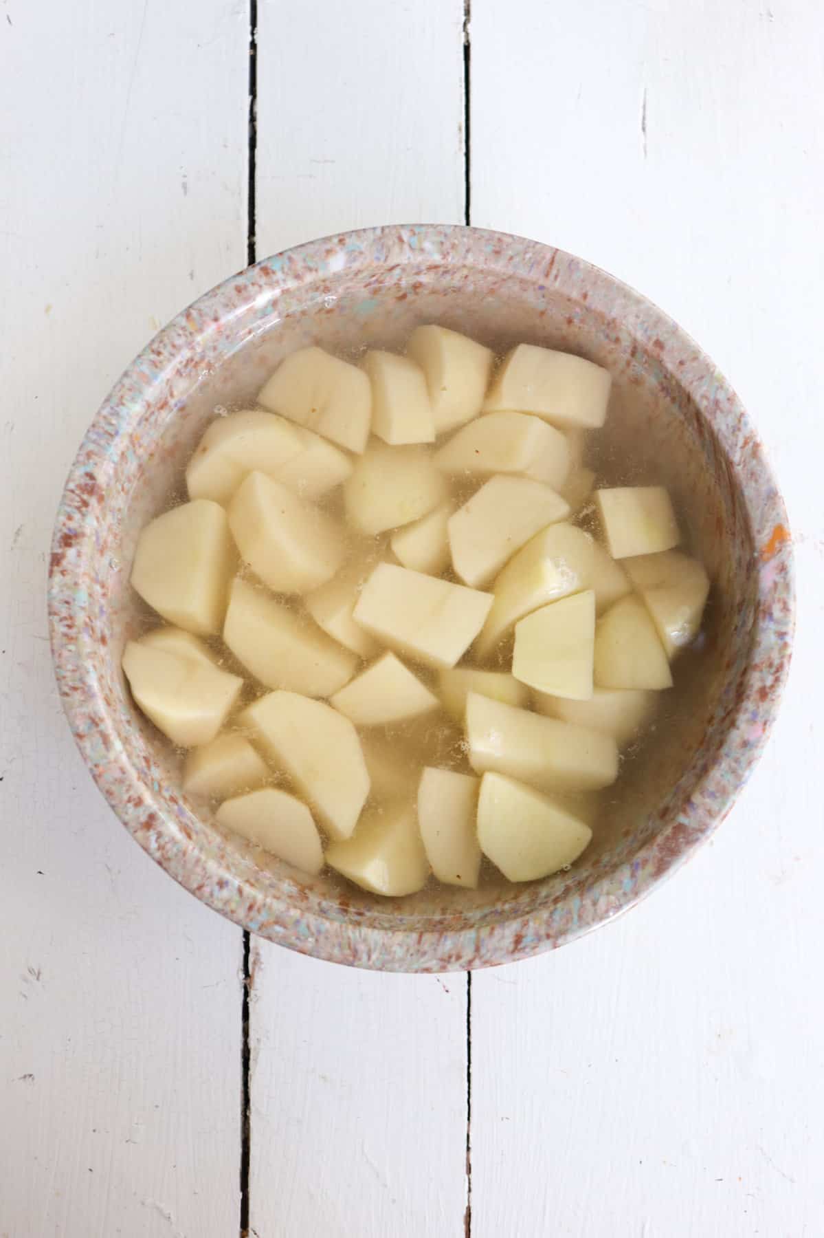 peeled potatoes soaking in water.
