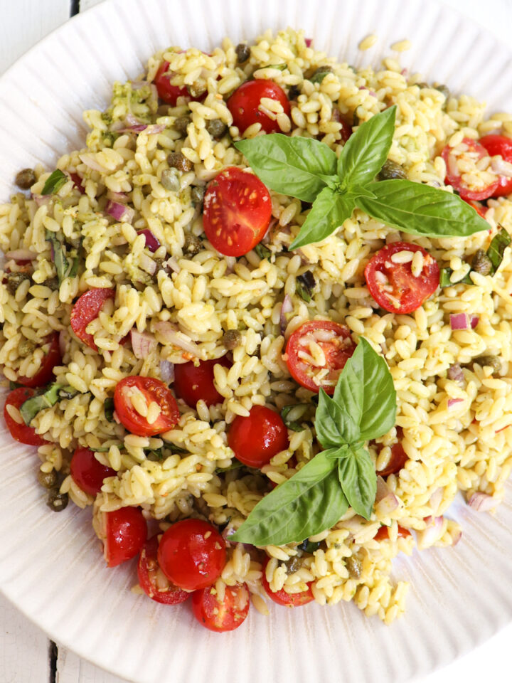 orzo salad with tomatoes and basil on a plate.