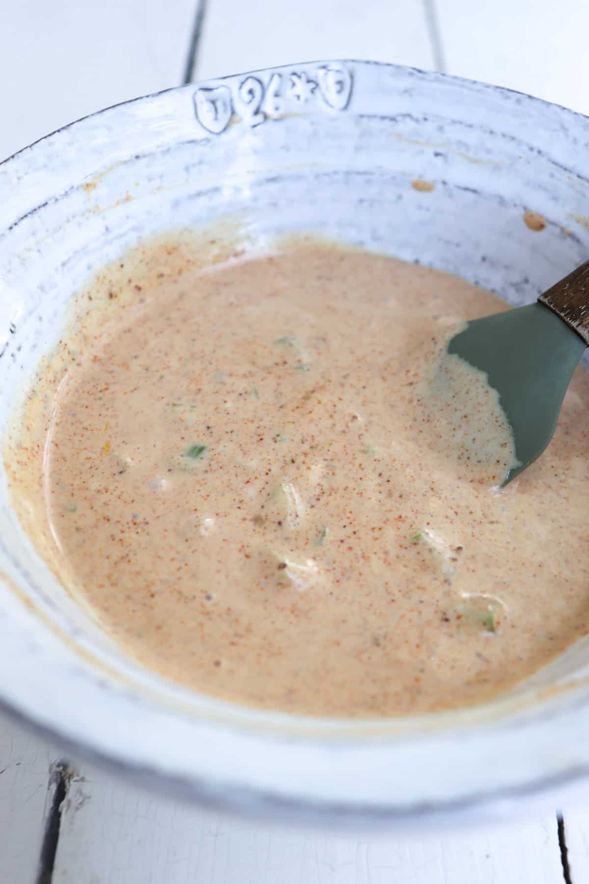 finished remoulade sauce in a white bowl with a small spatula.