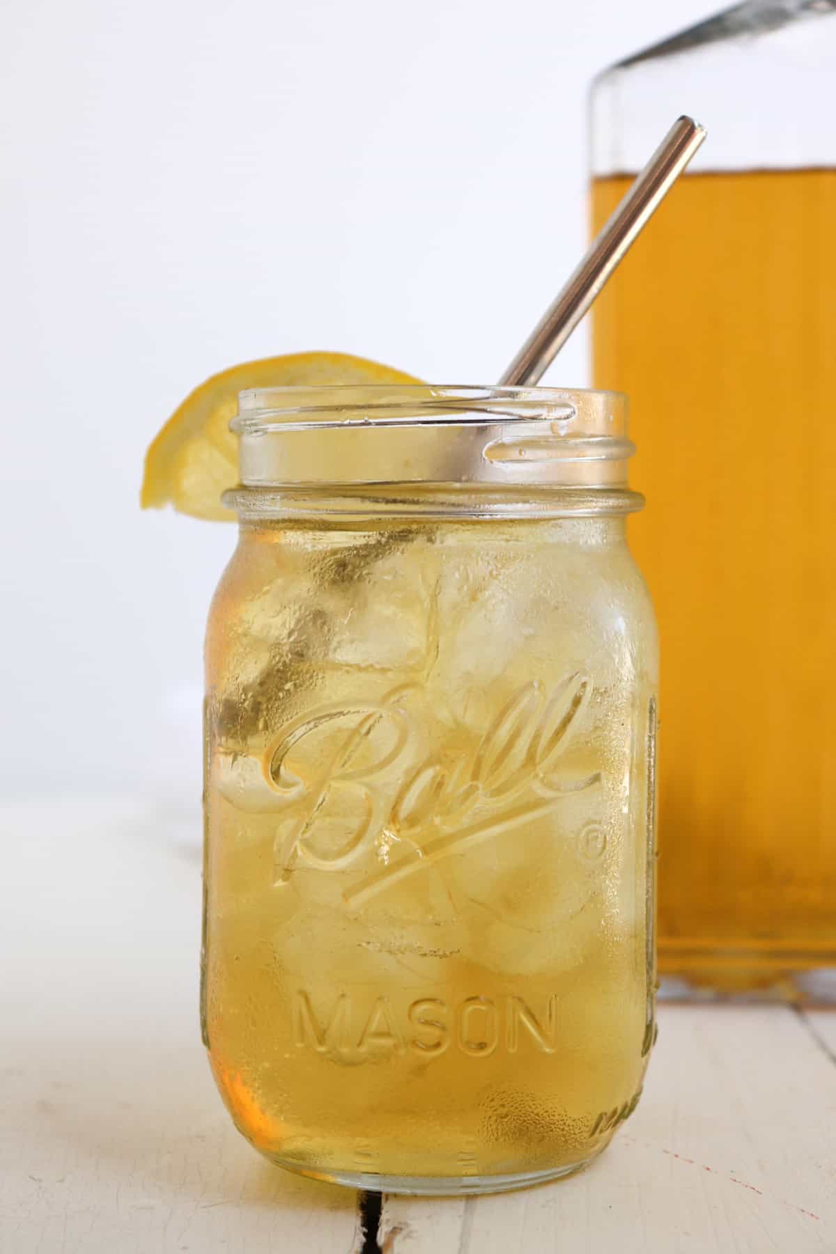 glass of iced tea with a straw and lemon wedge.