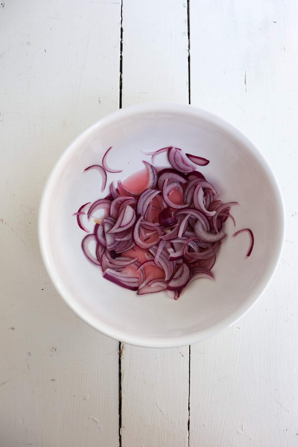 quick pickled onions in a white bowl.