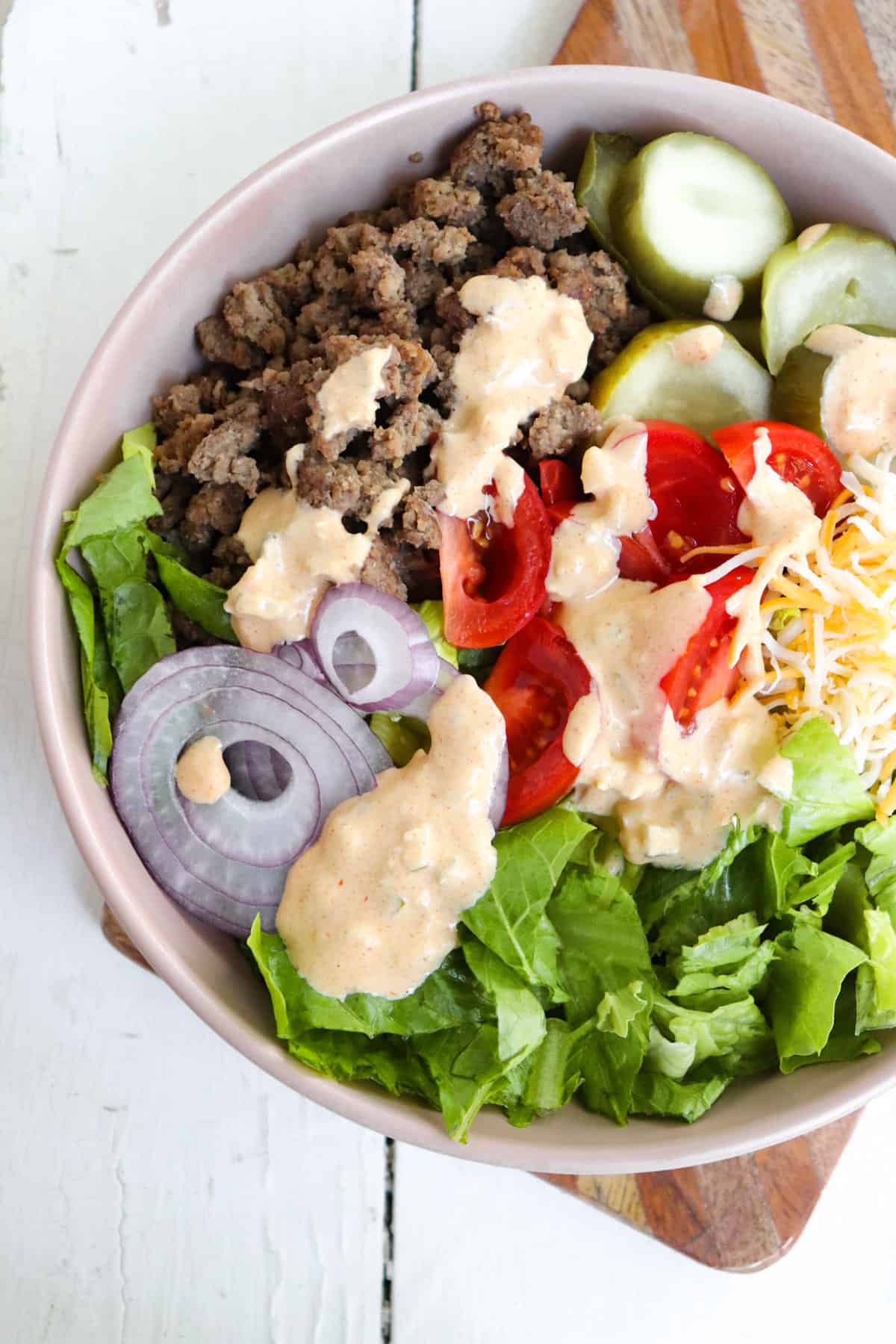 burger bowls with sauce drizzled over top.