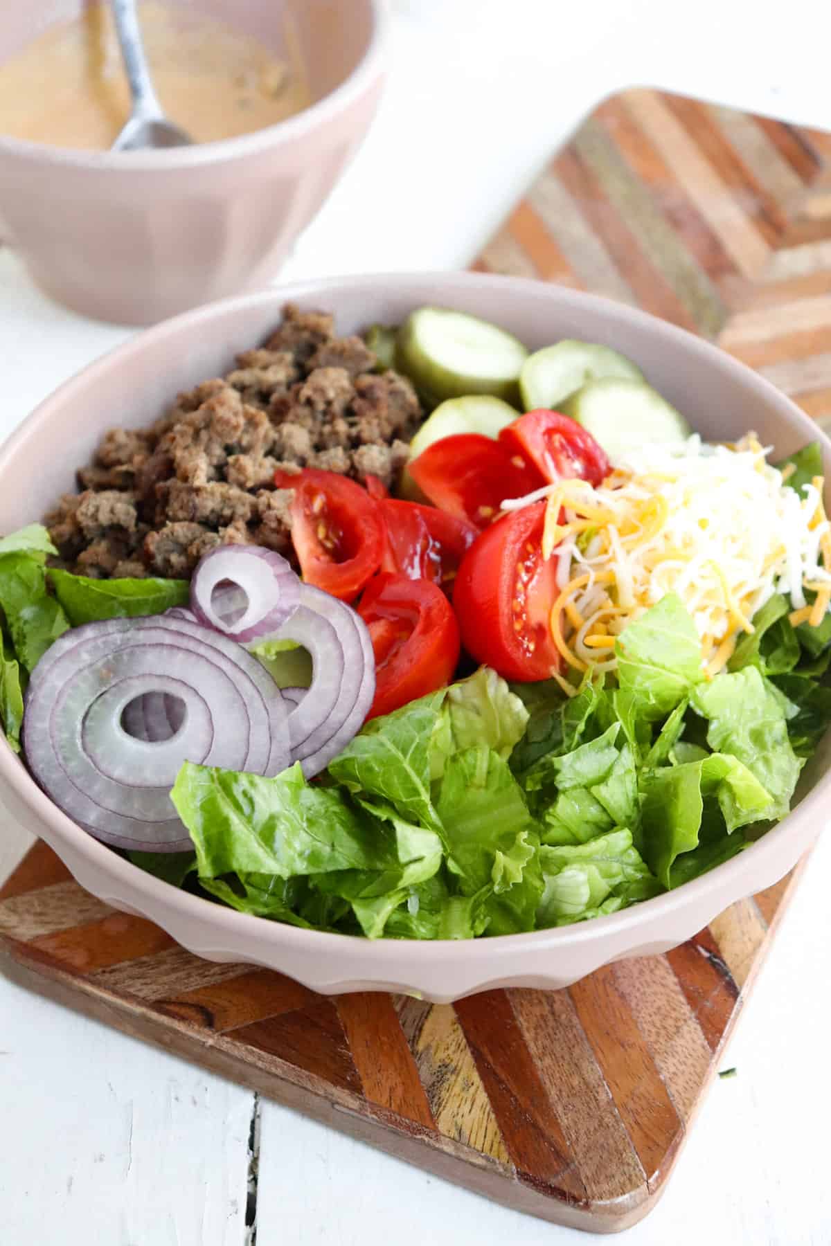 ground beef burger bowl with sauce in a bowl to the side.