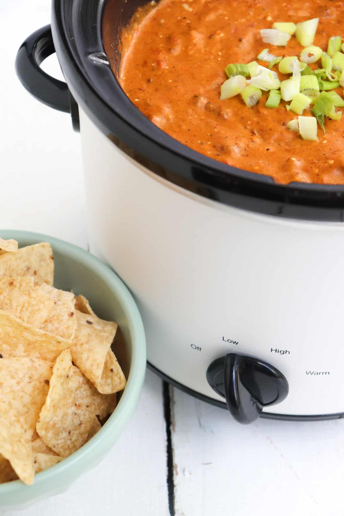 finished chili cheese dip with tortilla chips to the side.