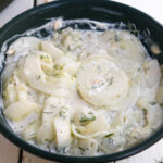 polish cucumber salad in a green bowl.