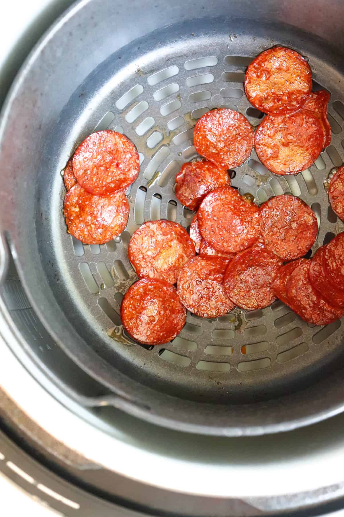 finished pepperoni in air fryer basket.