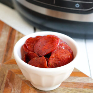 air fried pepperoni chips in front of ninja foodi deluxe.