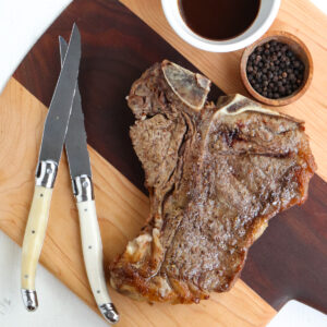 t bone steak that has been air fried and placed on cutting board.
