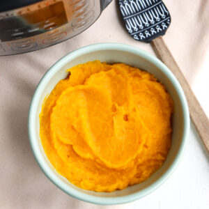 bowl of mashed pumpkin next to pressure cooker.
