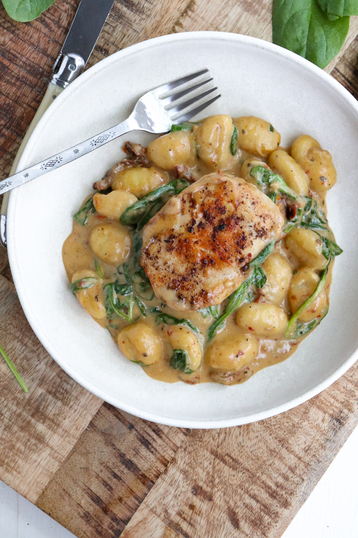 whole chicken breast on bed of creamy gnocchi.