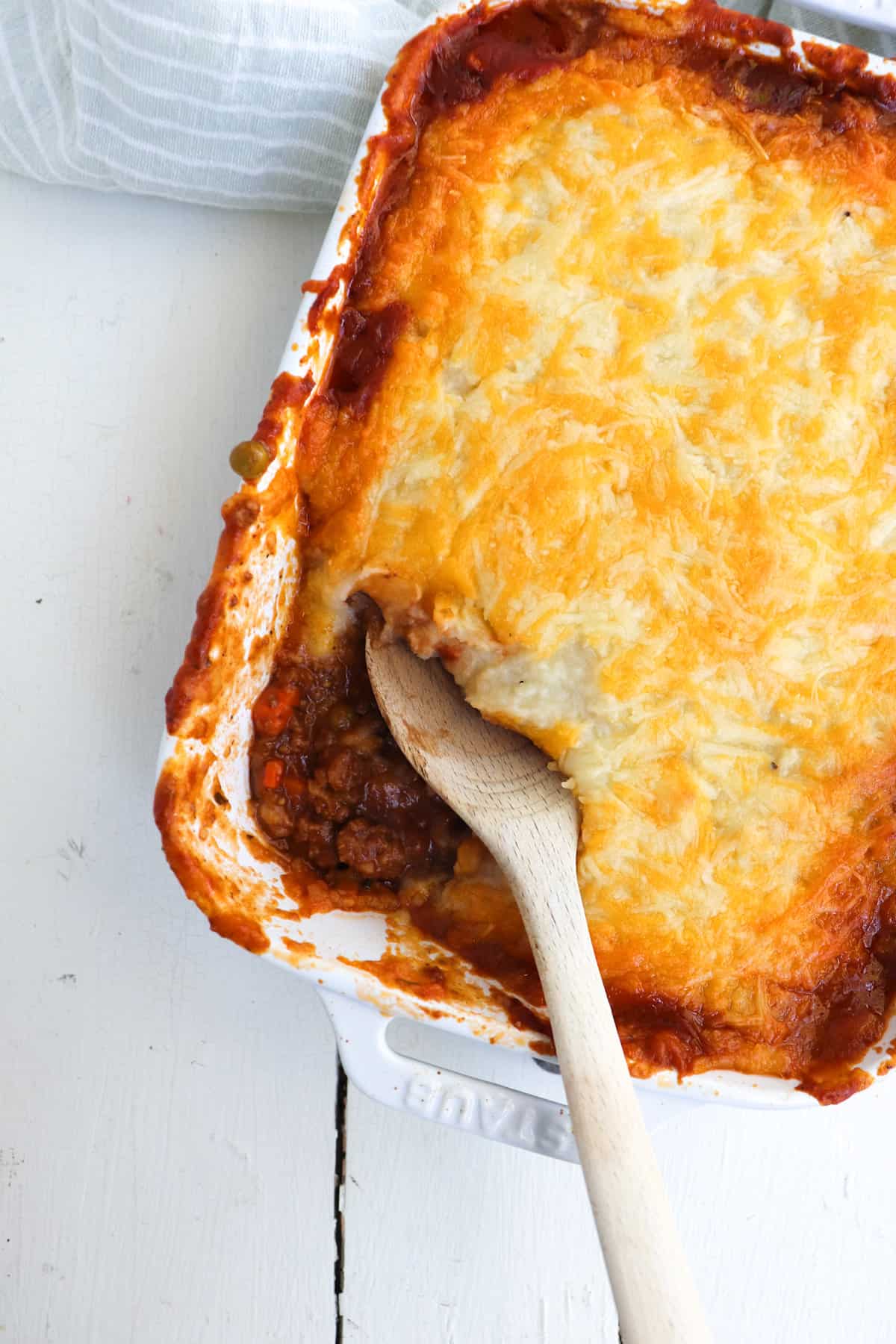 wooden spoon scooping a portion of venison shepherd's pie.