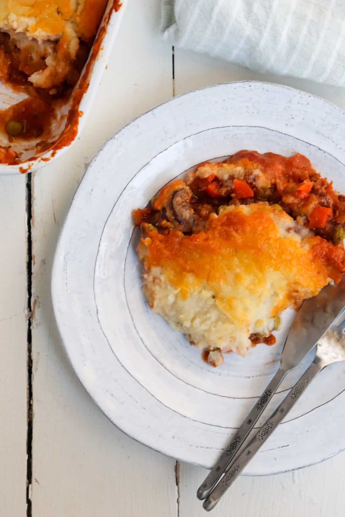 serving of dish with casserole in the background.