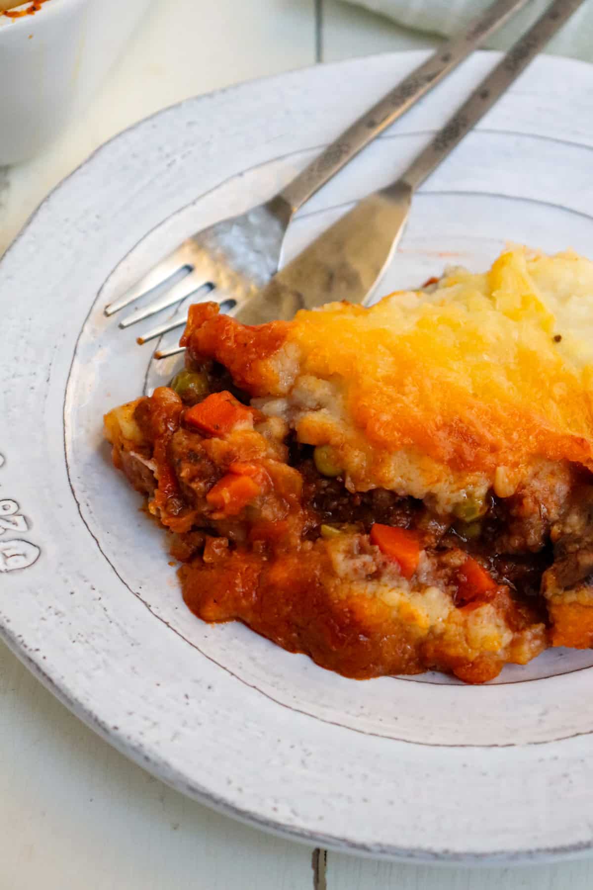 one serving of venison shepherd's pie on a white plate.