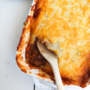 wooden spoon scooping a portion of venison shepherd's pie.