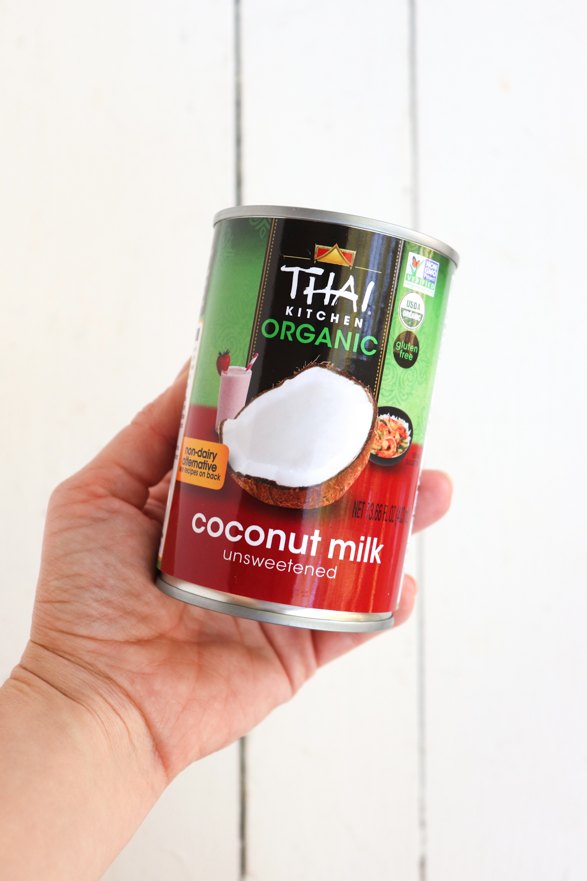 hand holding can of coconut milk.