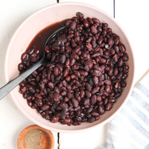 pink bowl of cooked black beans.