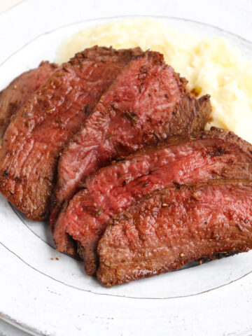 sliced venison with mashed potatoes.
