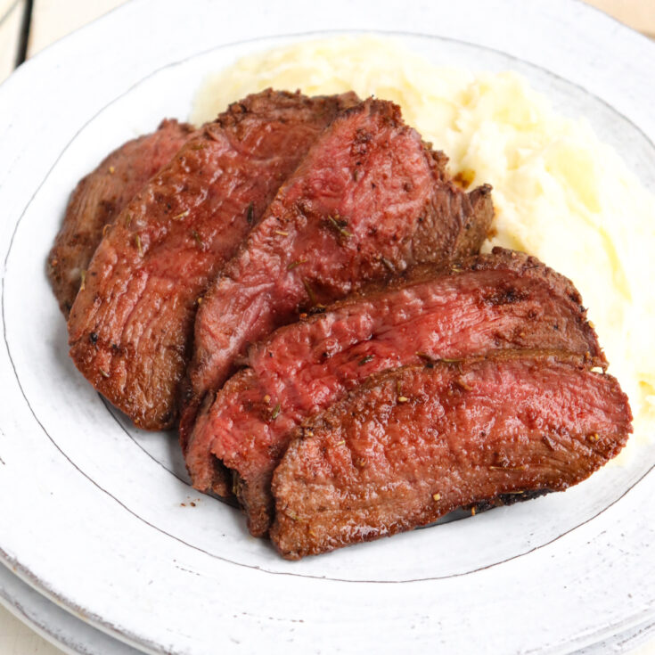 sliced venison with mashed potatoes.