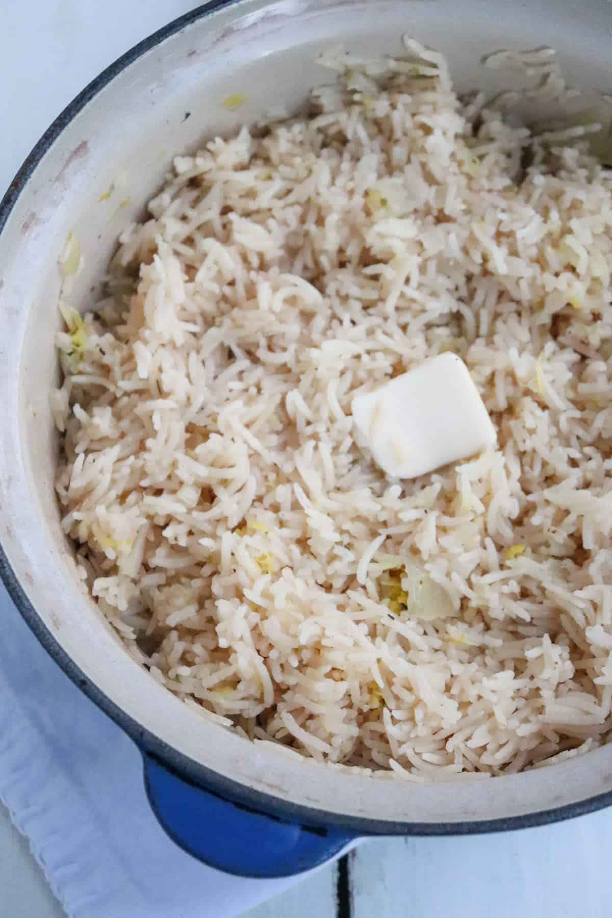 up close of finished rice in pot with pat of butter on top.