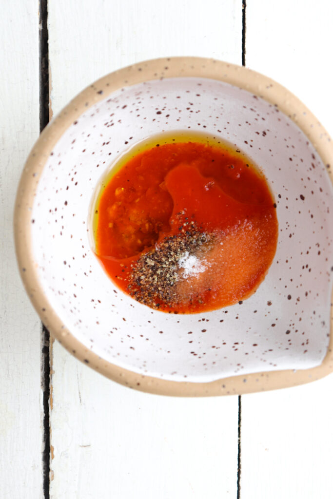 ingredients for chicken marinade added to a white bowl.