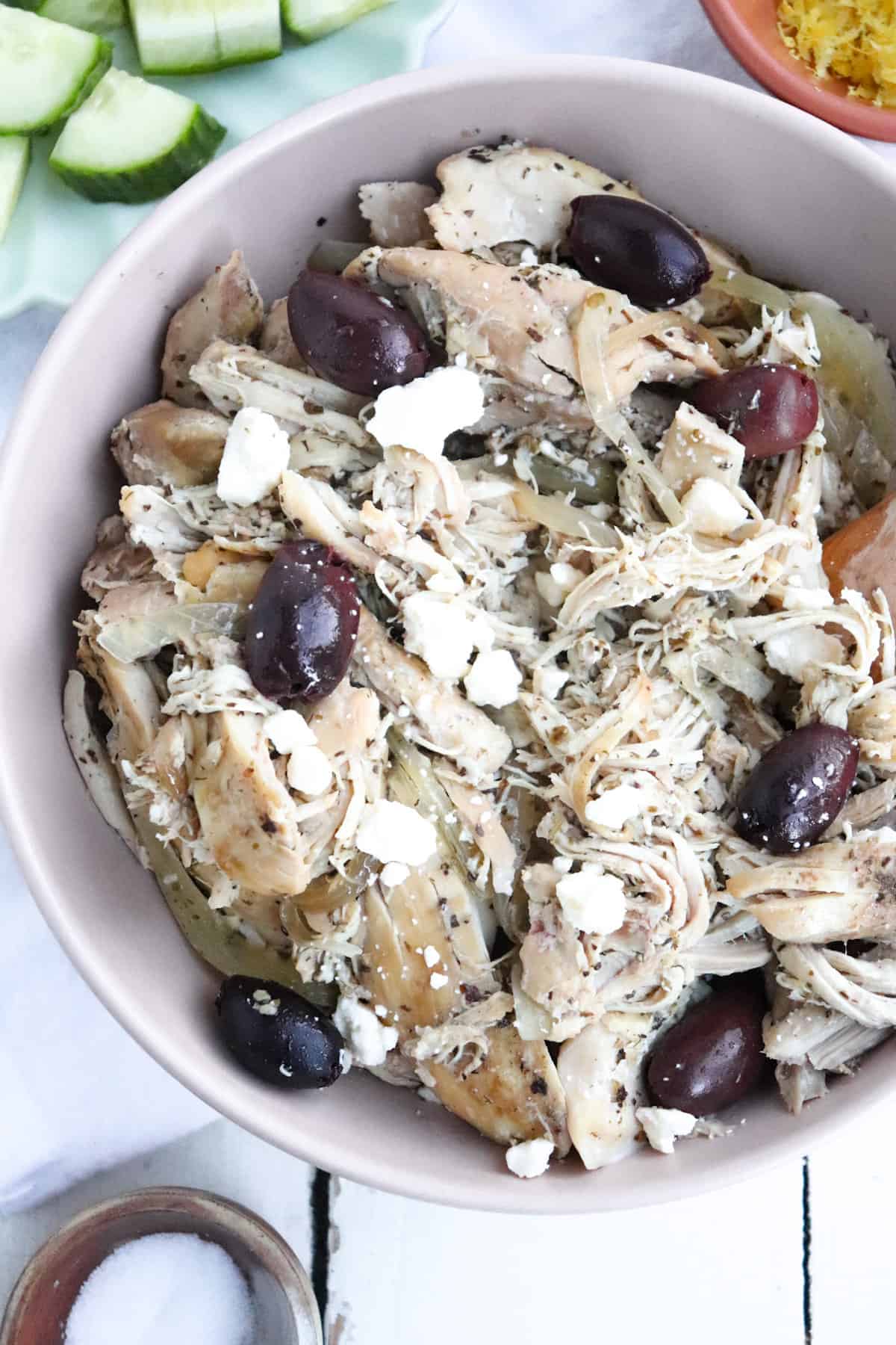 chicken in a serving dish with greek toppings around it.