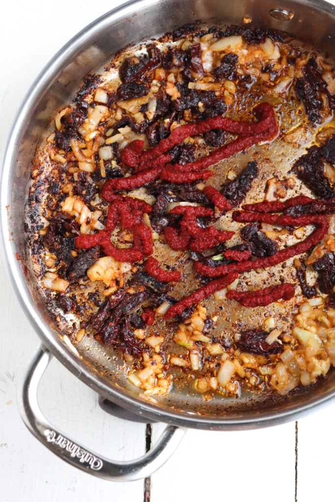 tomato paste added to skillet with other ingredients.