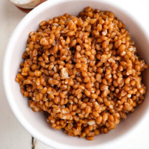 cooked wheat berries in a white bowl.