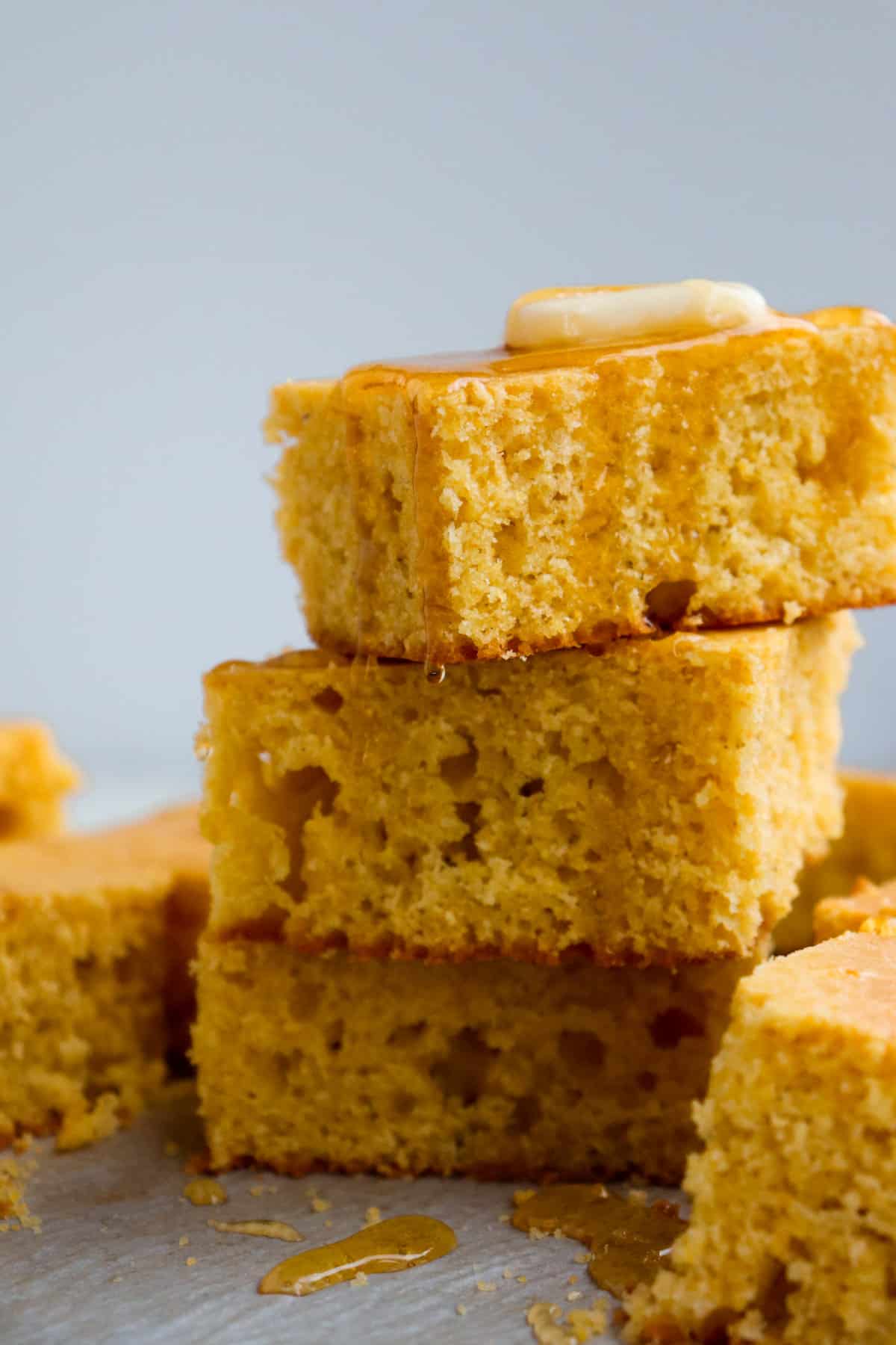 cornbread slices stacked with honey and butter dripping down.