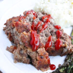 two slices venison meatloaf with ketchup drizzled on top.