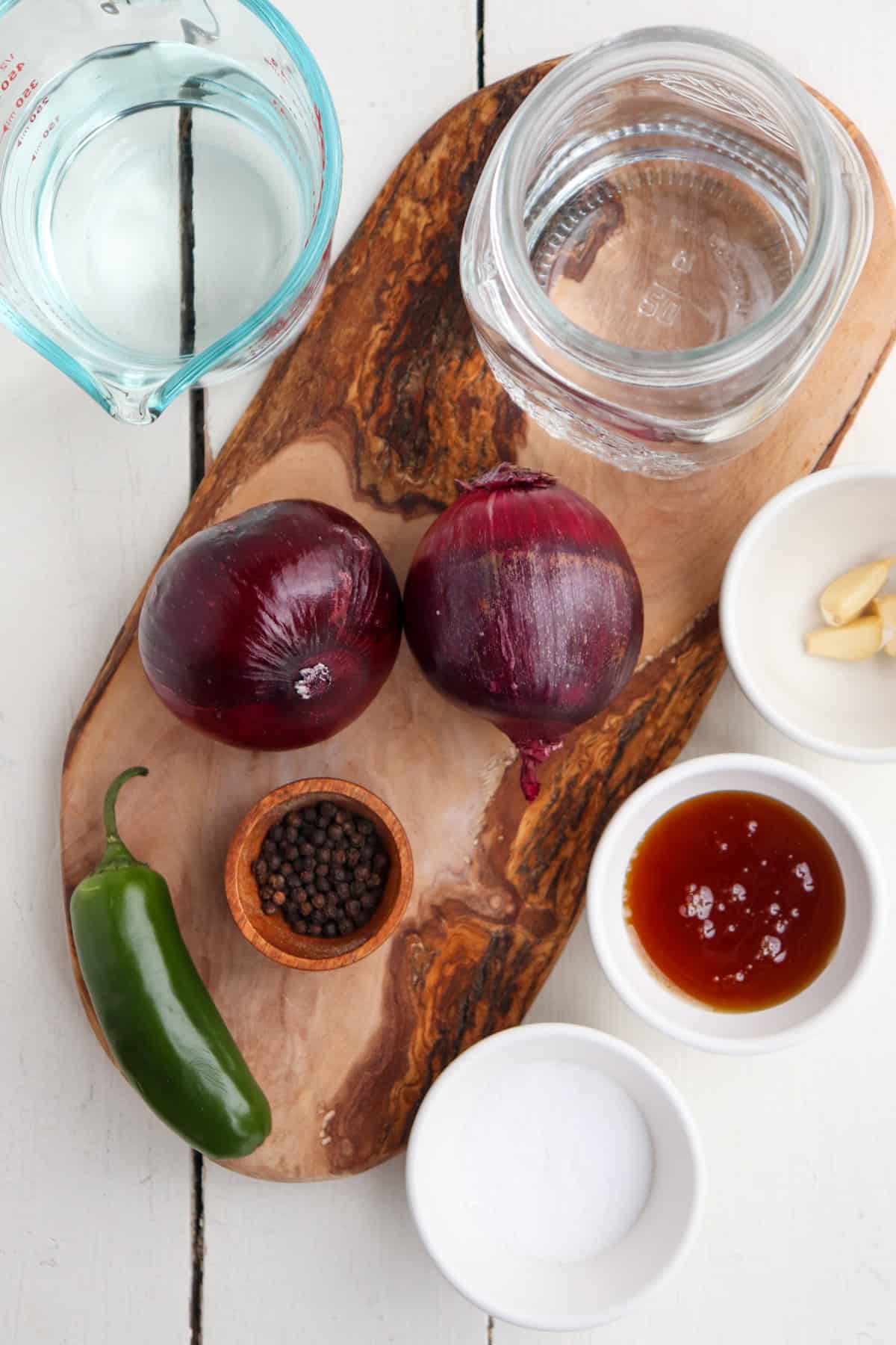 ingredients for mexican pickled onions on a wooden cutting board.