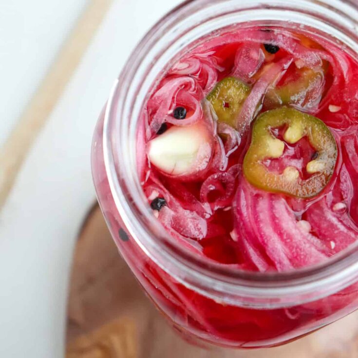 overhead of mexican pickled onions with jalapenos and garlic.
